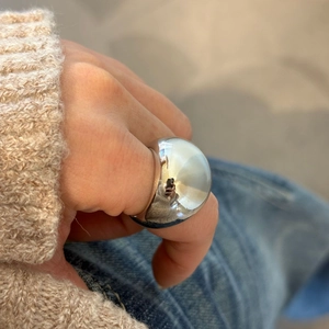 Nahaufnahme eines großen polierten Silber-Kuppelrings am Finger für einen modernen Look