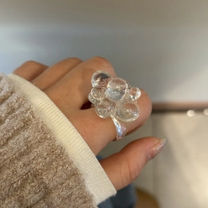 Makroaufnahme eines durchsichtigen Harzrings mit blasenförmigen Kugeln für modernen Stil