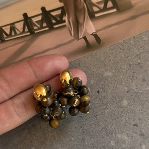 Detailopname van vintage tijgeroog steen oorbellen met een gouden afwerking