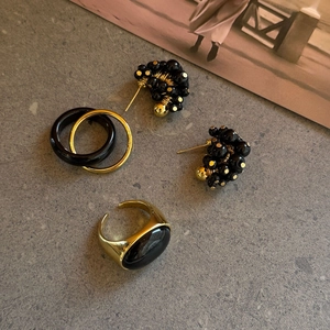 Detailweergave van tijgeroog sieradenset met zwarte ovale edelsteen ring en kralen oorbellen