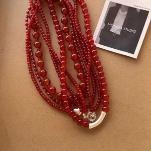 Detailed view of multilayer red agate beaded necklace with silver heart and OT clasp