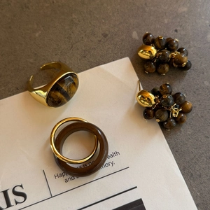 Detail van vintage gouden ringen en druifvormige oorbellen met natuurlijke tijgeroogstenen