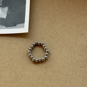 Polierter silberner Perlenring mit glänzenden Metallkugeln auf Vintage-Hintergrund