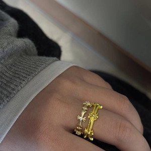 Close-up of gold-plated gothic cross rings set with sparkling zircon on hand