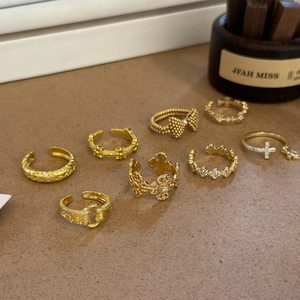 Flat lay of gold plated alloy rings set with zircon stones and cross pattern details