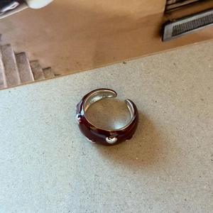 Detail of adjustable ring featuring deep red enamel and silver heart-shaped decorations