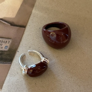 Close-up of vintage burgundy enamel resin ring and silver metal oval inlay ring