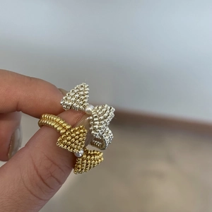 Detail of handmade beaded bow ring with miniature white pearl on polished bead surface