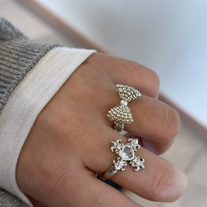 Silver bow ring with pearl and heart cross ring set worn by model for elegant style