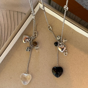 Détail de colliers à pendentif cœur long avec perles mixtes sur un plateau à bijoux