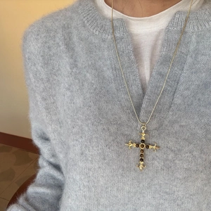 Gedetailleerd beeld van vintage gouden kruisketting met bruine tijgeroog stenen