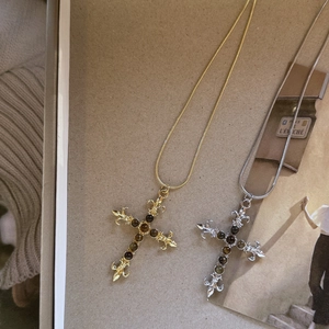 Detail van vintage kruiskettingen met tijgeroogstenen in gouden en zilveren afwerkingen