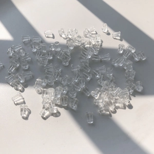 Primer plano de 100 cierres de silicona transparente para la fabricación de joyas DIY