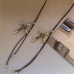 Macro detail van vintage kruis hangers met tijgeroog steen in goud en zilver finish