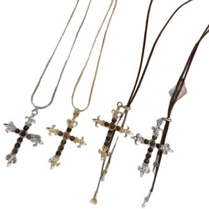 Vintage kruisketting met tijgeroog steen en fleur-de-lis detail op een witte achtergrond
