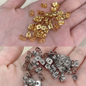 Lote de cierres de mariposa para pendientes en color oro y plata mostrados en la mano