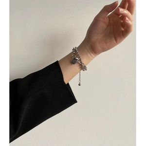 Pulsera de doble capa en acero con colgante de corazón y cierre OT en la muñeca