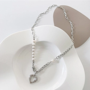 Detailansicht der barocken Perlenkette mit einem strukturierten Herzanhänger in Silber