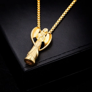 Vue rapprochée du pendentif ange doré avec chaîne croisée sur fond de cuir noir