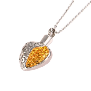 Silver heart urn necklace with amber rhinestones and hollow scroll patterns