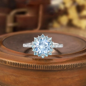Macro shot of light blue cluster ring with sunflower setting and fine gemstone facets