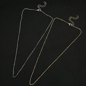 Detail of silver and gold O-chain necklaces with metal beads and lobster clasps