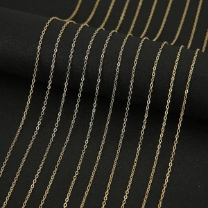 Polished gold snake-style O-chain copper necklace layered on a black display stand