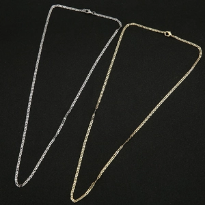 Detail of gold and silver flat snake chains with lobster clasps on black surface