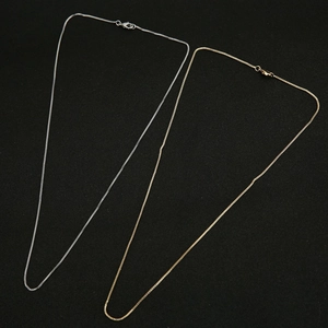 Detail of silver and gold plated copper snake chains with lobster clasp closures