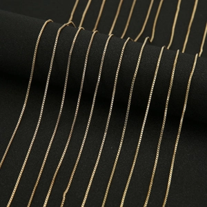 Detailed view of polished golden box chains neatly arranged on a jewelry display
