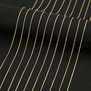 Close-up of golden snake chains displayed on a black stand for DIY jewelry making
