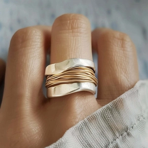 Macro shot of silver wide band ring with gold wire wrap detail for a minimalist industrial look