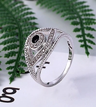 Macro di un anello d'argento con motivo occhio greco, pietra nera e zirconi incastonati