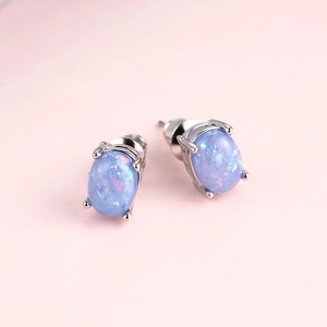 Minimalist oval light blue opal stud earrings with silver four-prong setting for women