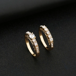 Elegante conjunto de anillos dorados para pareja con circonitas y patrones de filigrana