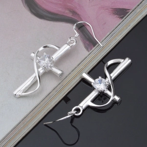 Silberne Kreuzohrringe mit zentralem Kristallstein und elegantem geschwungenem Metalldesign