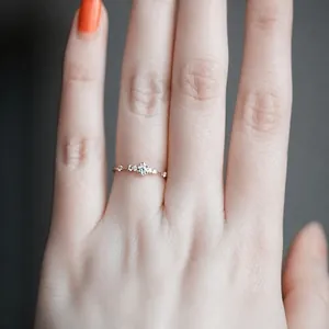 Nahaufnahme eines minimalistischen Silber-Diamantrings am Finger mit funkelnden Steinen