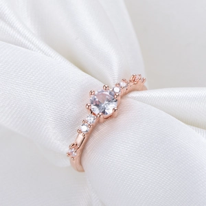 Detailaufnahme des roségoldenen Diamantrings auf elegantem weißem Seidenhintergrund