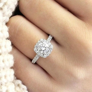 Elegante anello di fidanzamento in argento con pietra tonda e montatura halo sulla mano