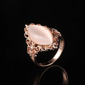 Vintage rose gold filigree ring with marquise opal stone on black reflective surface
