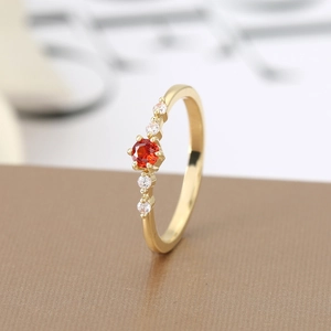 Detail view of gold-plated ruby ring showing elegant four-prong setting and side crystals
