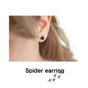 Minimalist black spider stud earrings for men and women shown on model's ear