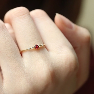 Elegant gold ruby ring with side diamonds worn on finger for a luxury fashion look