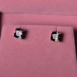 Macro shot of square rainbow opal stud earrings in a pink velvet jewelry box