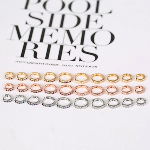 Collection of gold and silver mini huggie earrings with colorful zircon stones