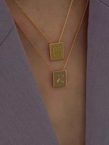 Minimalist gold titanium steel necklace featuring M and Z square letter pendants on model