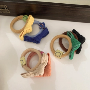 Détail de chouchous en tissu côtelé avec nœud et étiquettes souriantes en couleurs variées