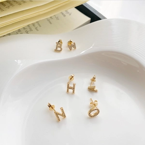 Elegant 925 silver needle gold letter earrings with micro-set zircon on ceramic tray