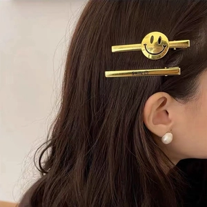 Minimalist gold metal hair clips with smile design and pearl earrings for women