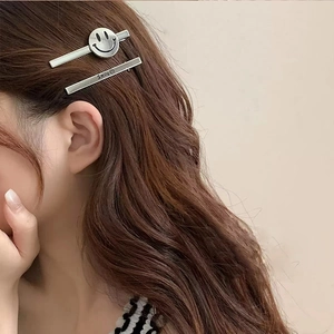 Two-piece silver metal hair clip set featuring smiley face and Smile engraving on hair